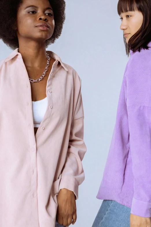 two women one with an afro and one without, both standing facing one another