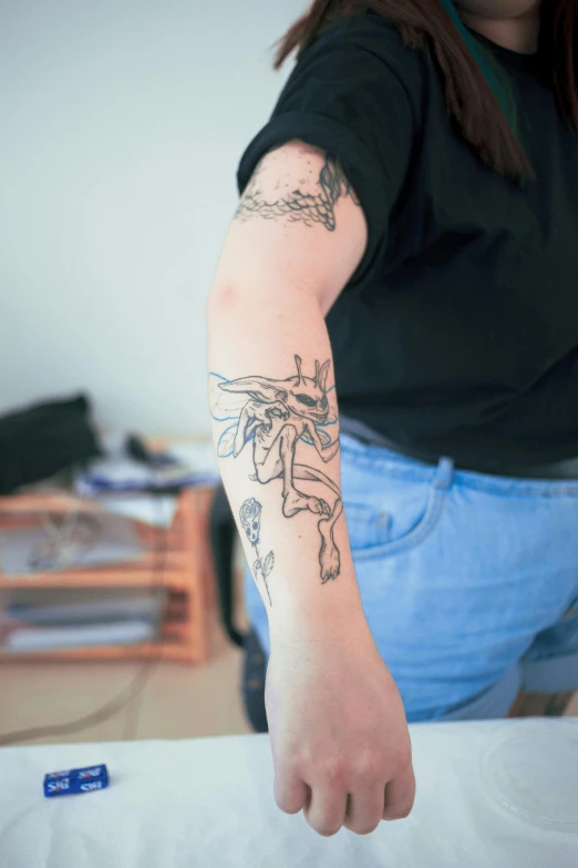 a woman with tattoos on her arm and a toothbrush