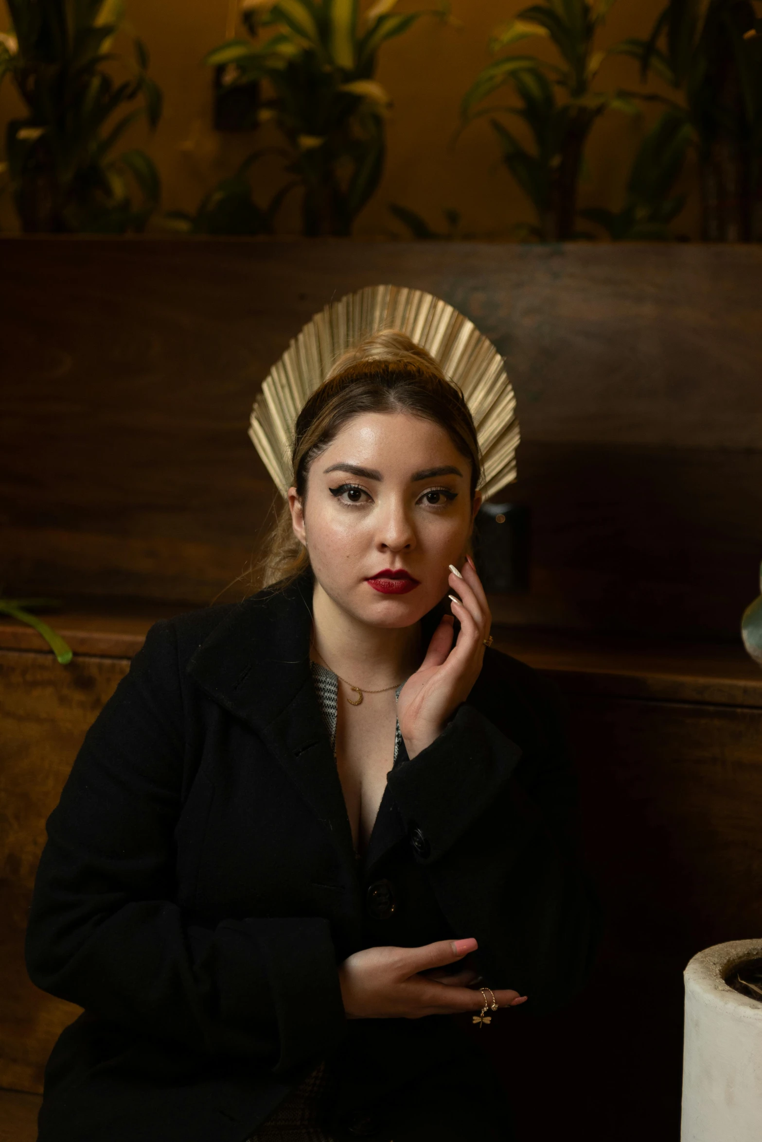 woman sitting with hand resting on her face while talking on a cell phone