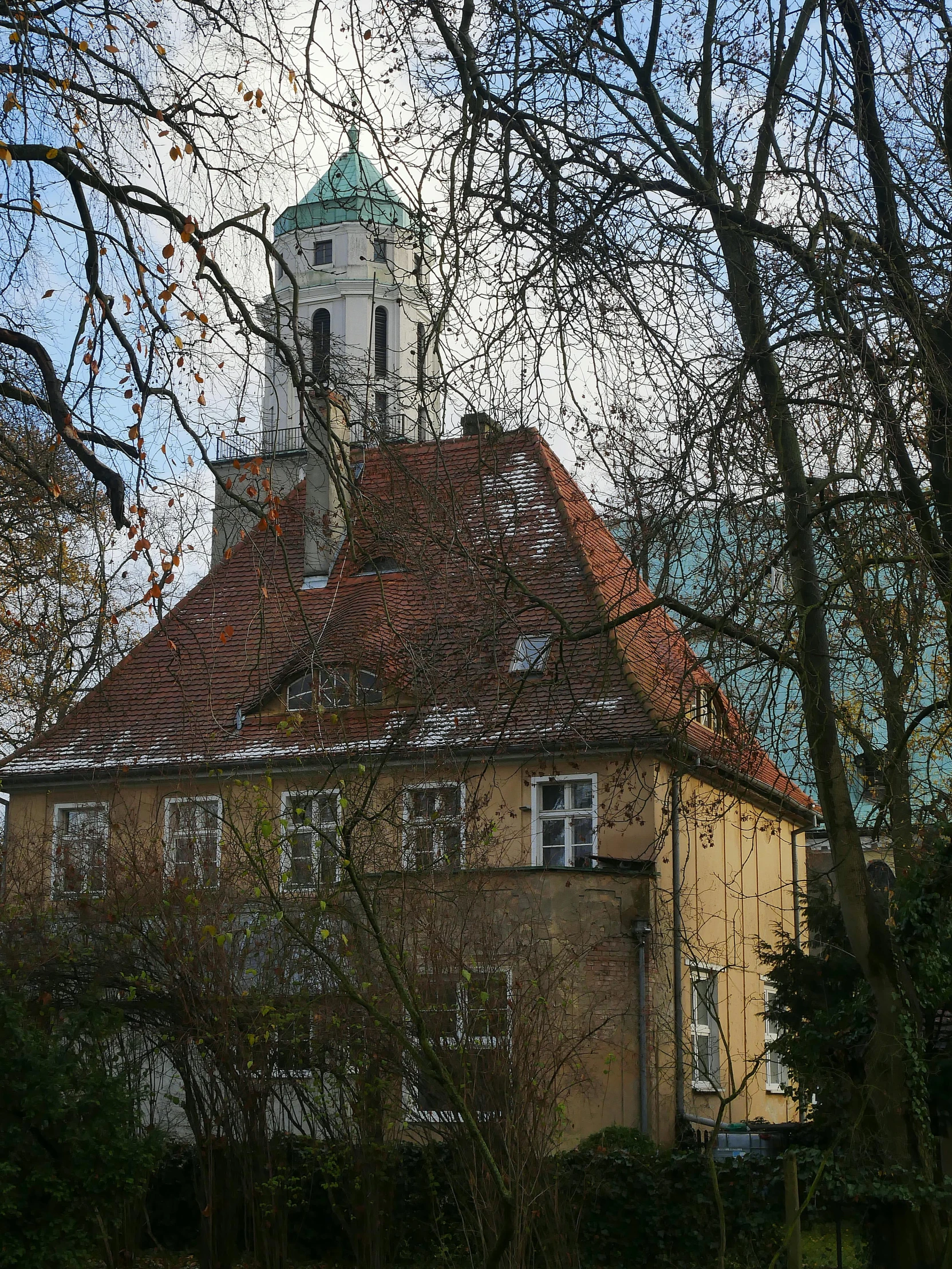 a brown building with a clock tower next to trees