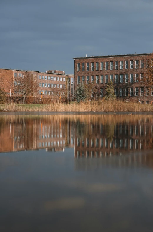 a building with windows reflecting in a lake