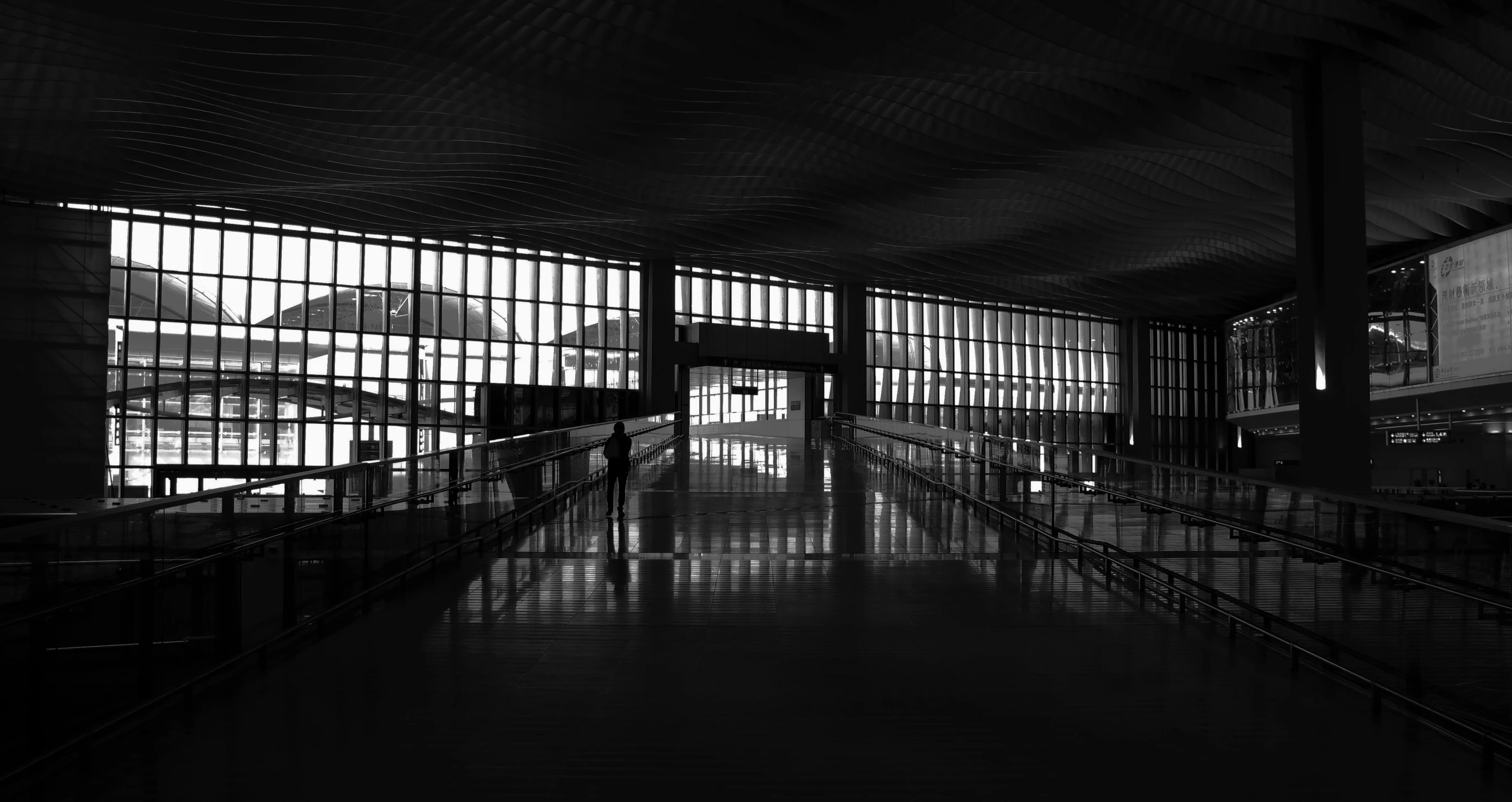 an empty passenger terminal at the airport, with windows to let in some light