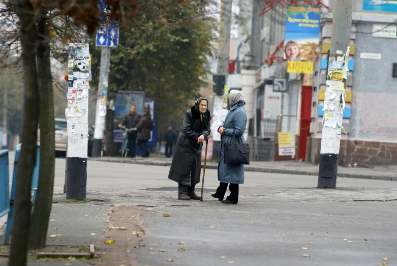 two women are on the side of a street talking