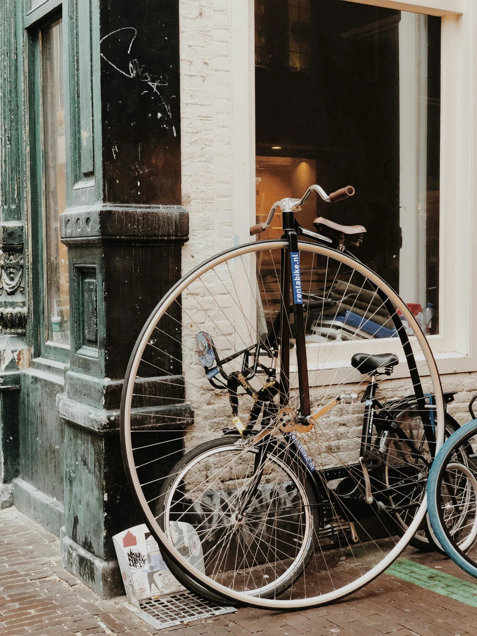 two old bicycle parked outside a brick building