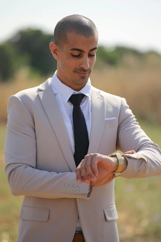 a man wearing a suit is checking his wrist strap