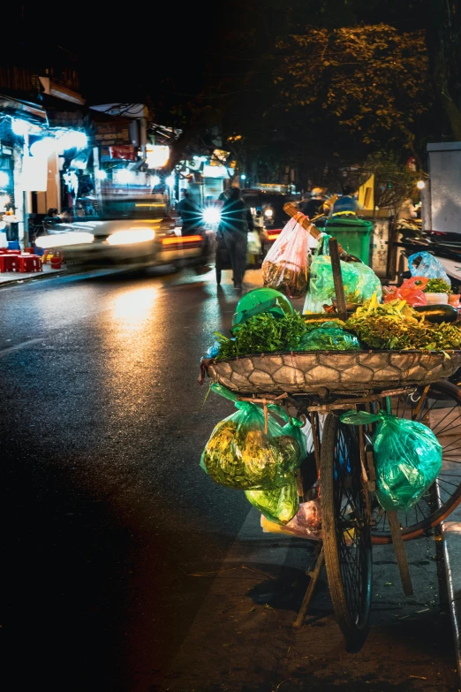 a cart full of food on a busy street at night