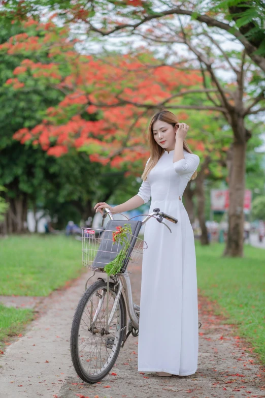 a woman in white dress holding a bike