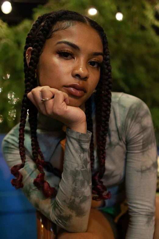 a young woman poses with her hand on her shoulder