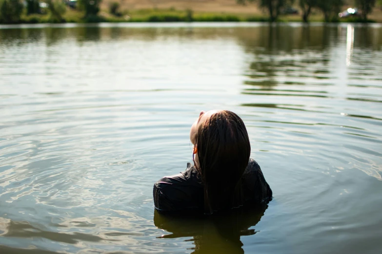 a woman is in the water near a tree