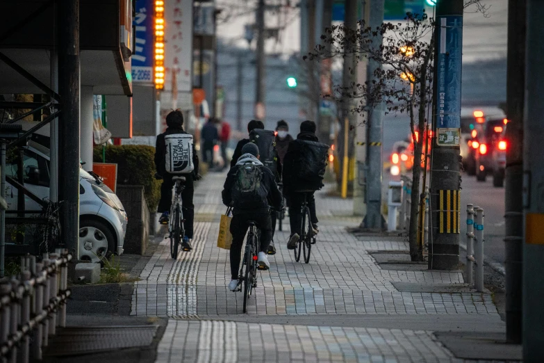 three men ride their bicycles down the street