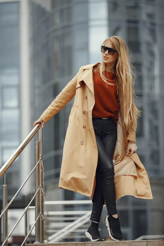 a woman is walking up some steps while wearing a long coat