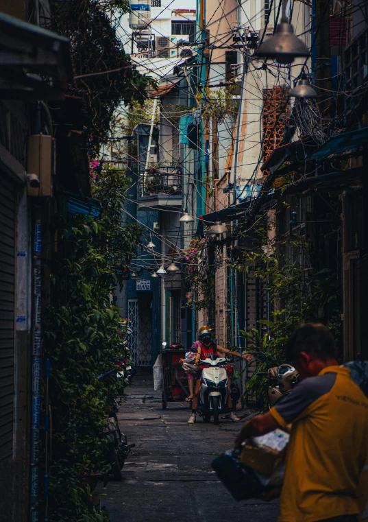 a city alley with several people walking down it