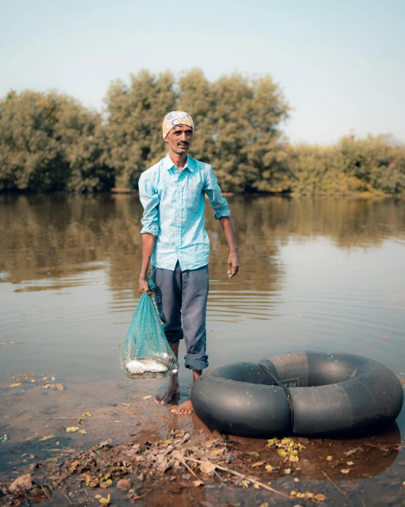 a man in a lake standing with a float next to his body of water