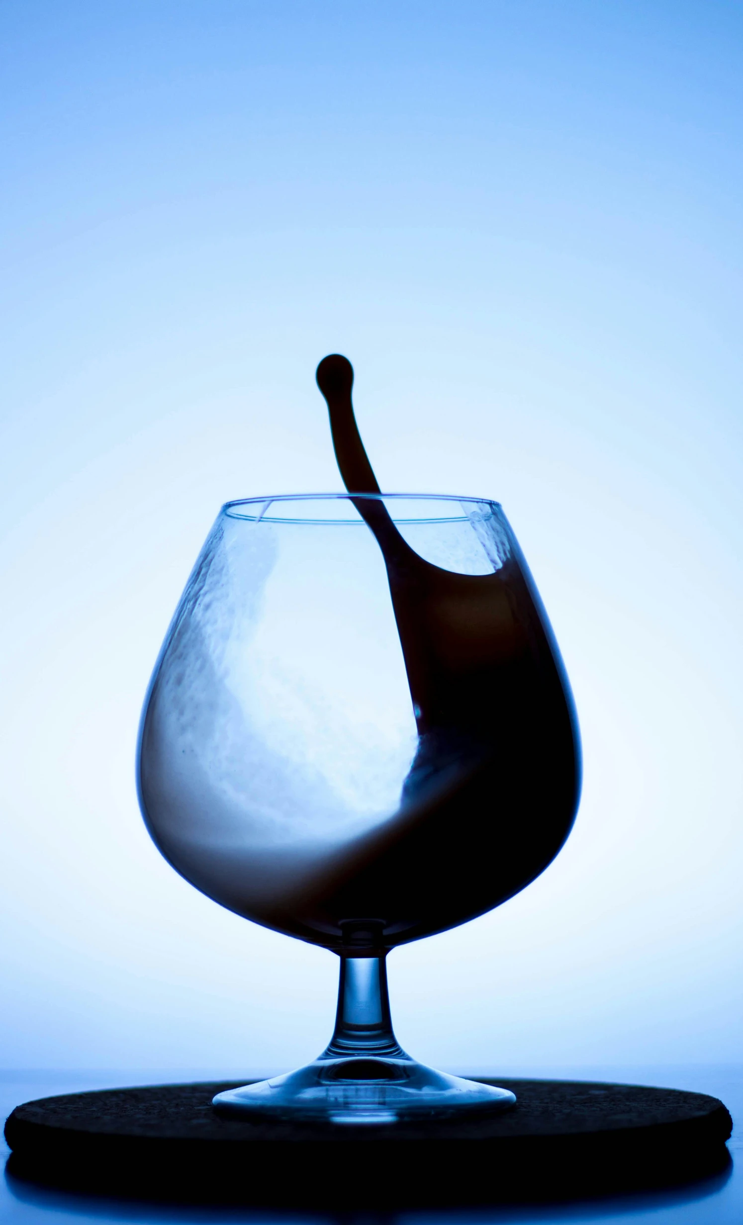 a closeup view of a wine glass with a bottle pouring into it