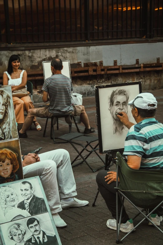 a group of people are sketching on large pictures