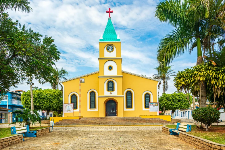 an old yellow church with a green steeple