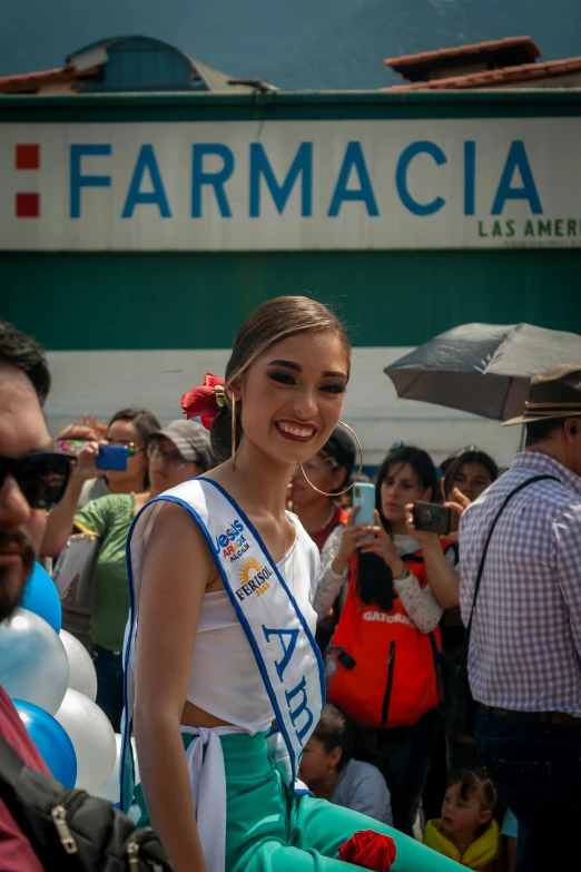 a pretty young lady standing in front of a crowd of people