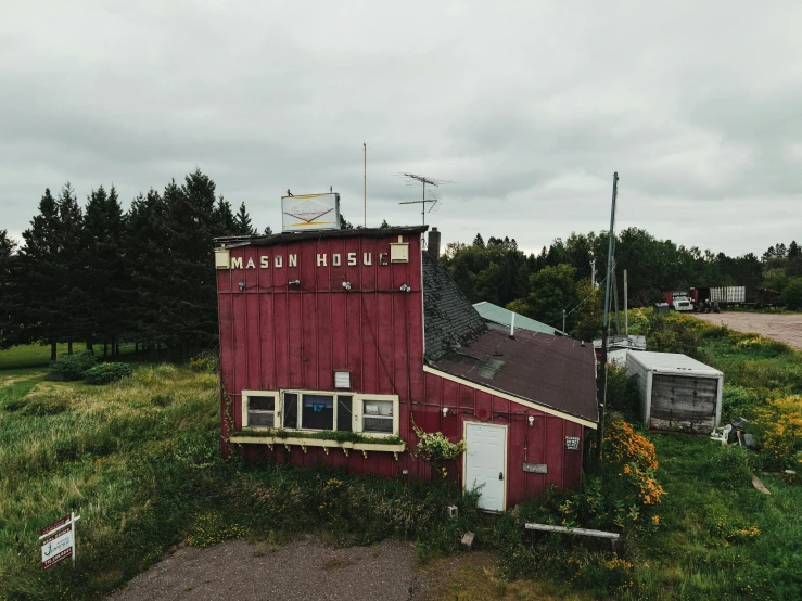 a small red barn in a field next to a road