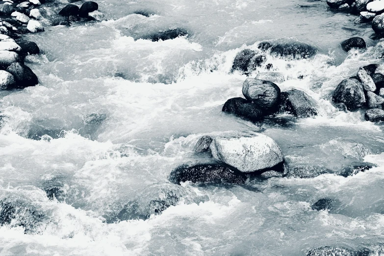 water in the river with rocks coming down it