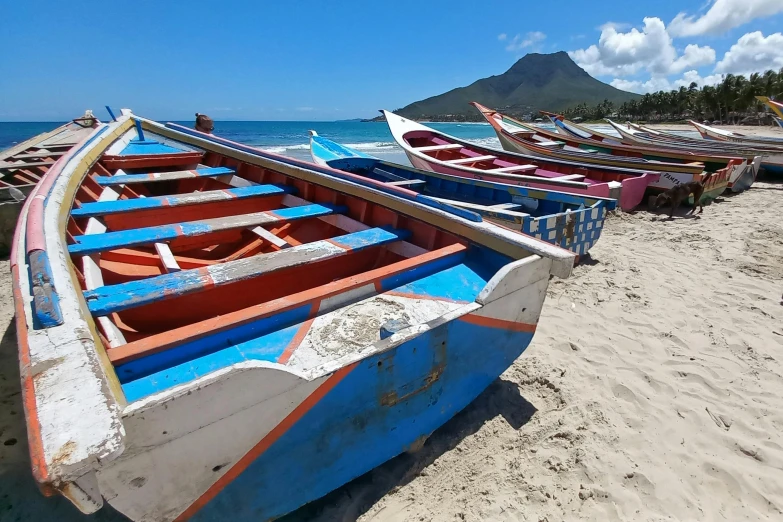 a group of boats on the sand by the water