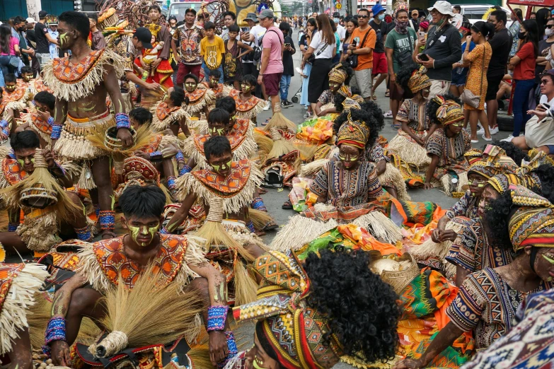 a parade of native people dressed in native dress and headdress