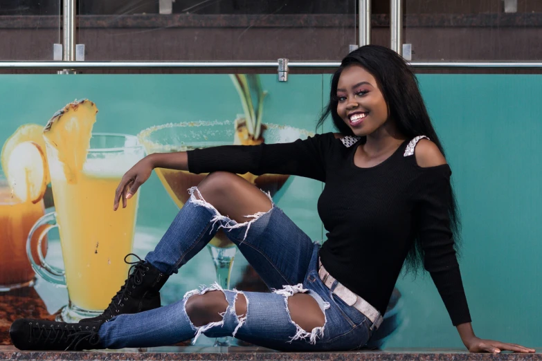 a woman posing for the camera wearing ripped denim and black boots