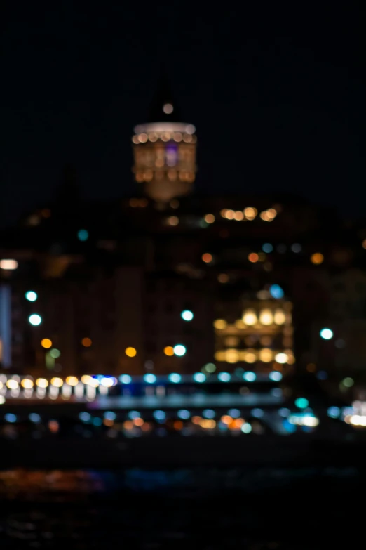 blurred image of a clock tower with night lights in background