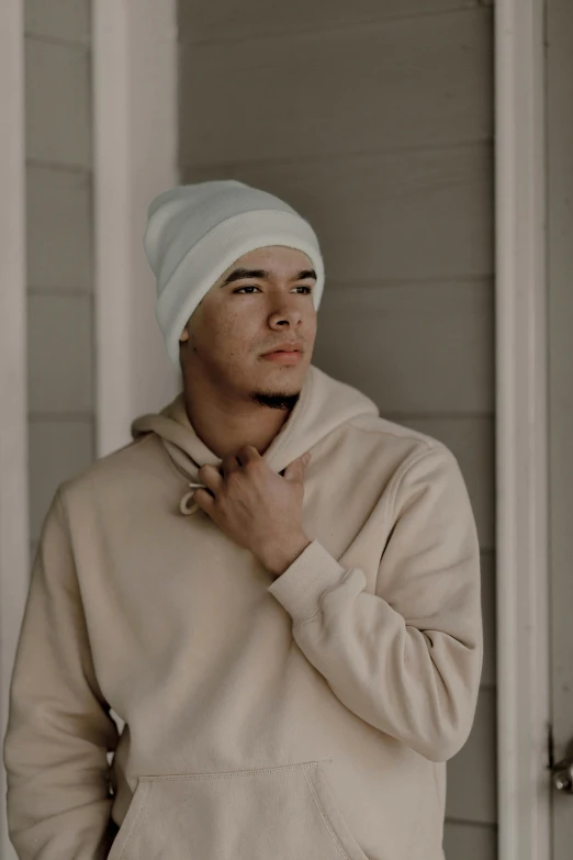 a man standing next to a door with his hands under his chest