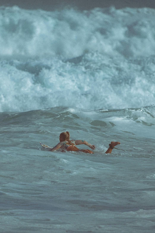 two people on surfboards in the water and with a wave