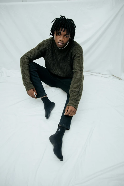 the young man has long black socks and a green sweater