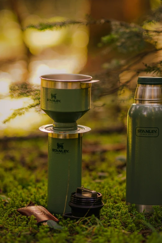 a couple of metal flasks sitting on top of a green field