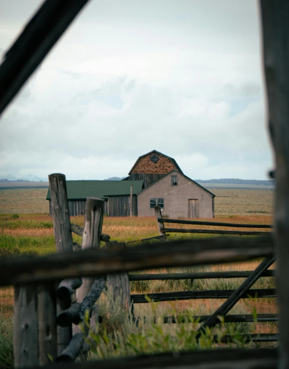 the building is made of wood and has an old looking fence