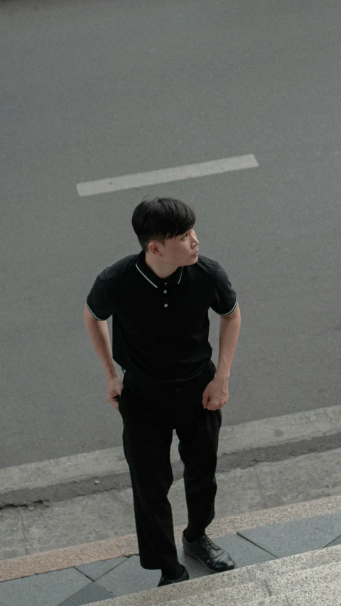 a young man standing on top of a sidewalk