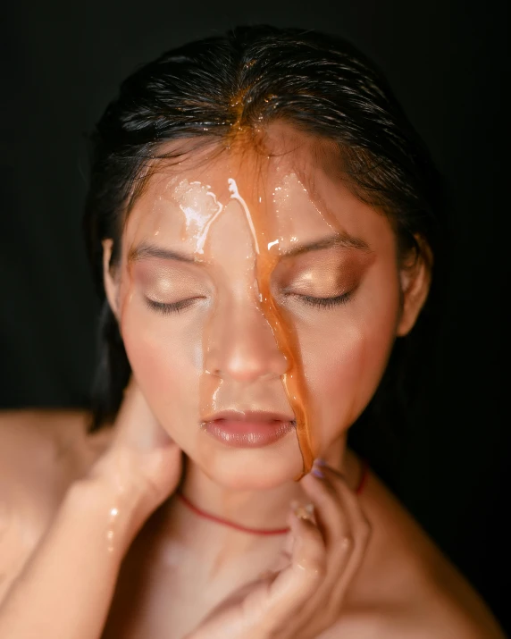 a woman squeezing syrup from her face