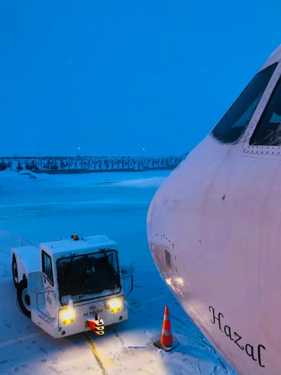 a car sits in the snow next to a white plane