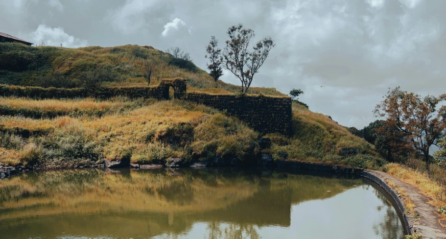 a couple of houses sitting on a cliff above a lake