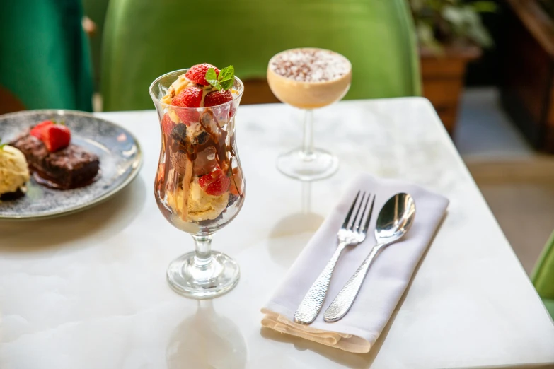 an ice cream sundae and other desserts are on a table