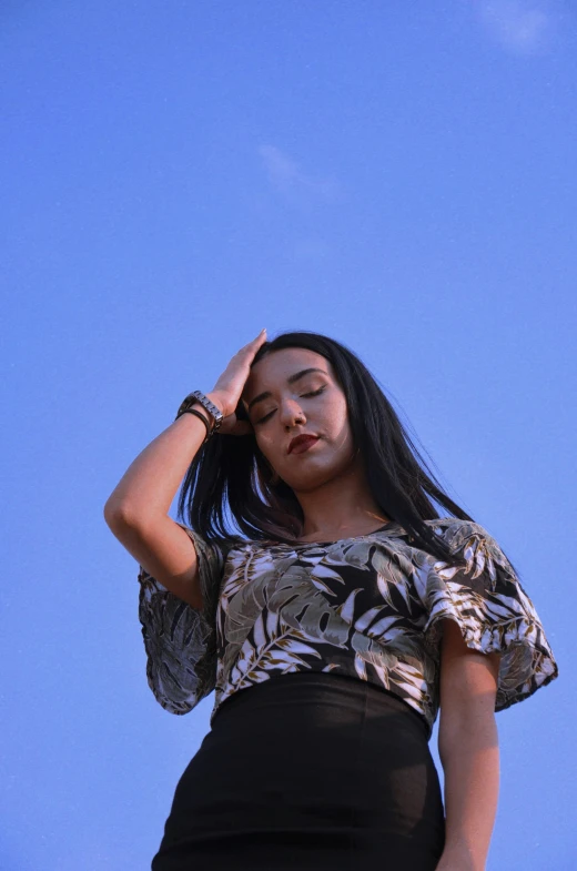 a woman standing against a blue sky wearing black and white outfit