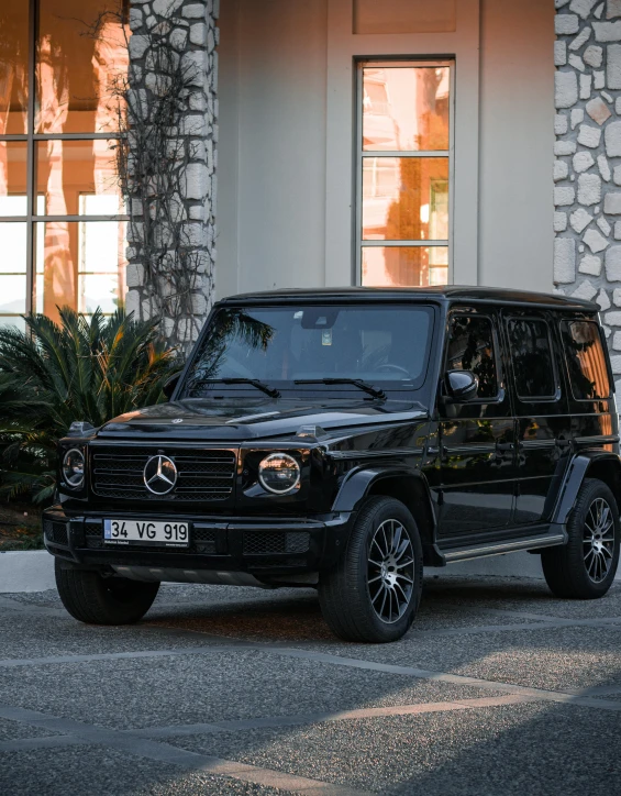 a mercedes benz g - class is parked outside of a building