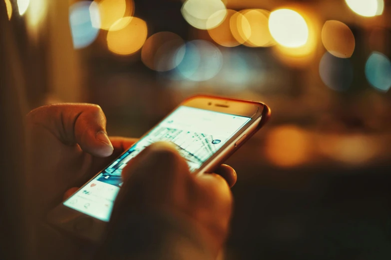 a hand holding a cell phone with a blurry background