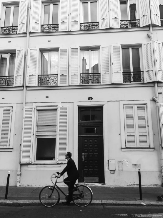 a person riding a bike down the street in front of a building