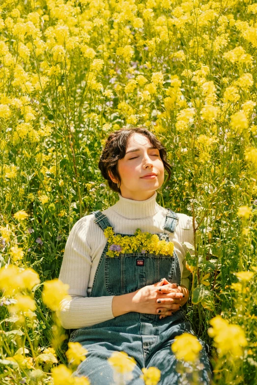 a woman sitting in a field with her eyes closed