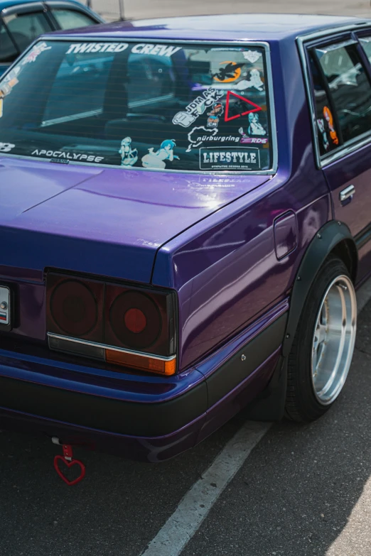 a purple car with stickers parked in a parking lot