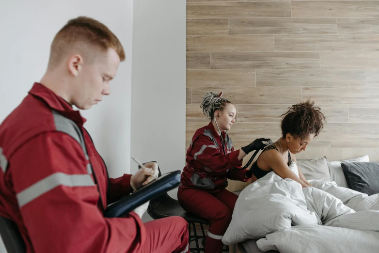 a man and woman in red sit on their bed