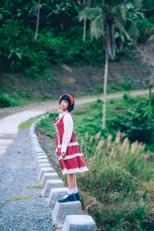 the girl is standing in a dress