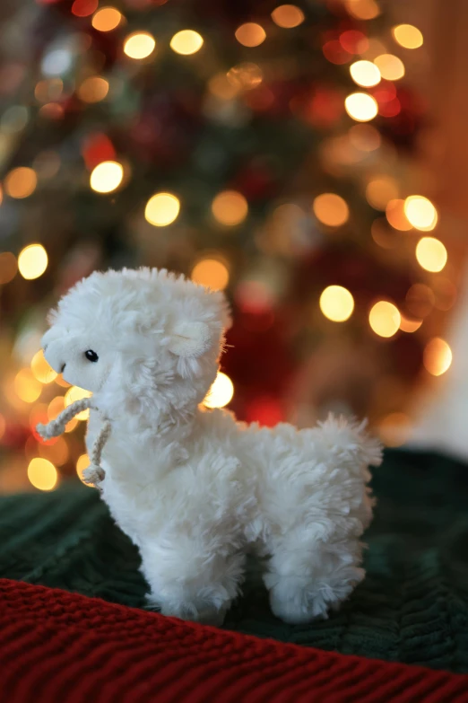 there is a stuffed white animal near the christmas tree