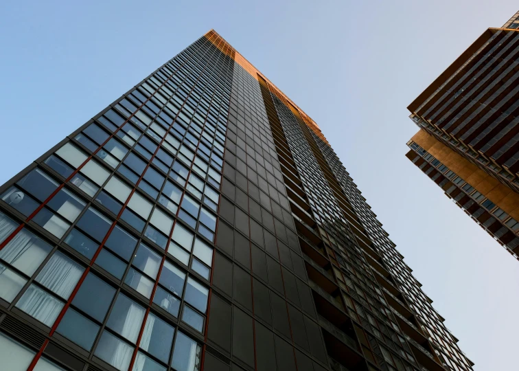 two buildings with lots of windows in front of the sky