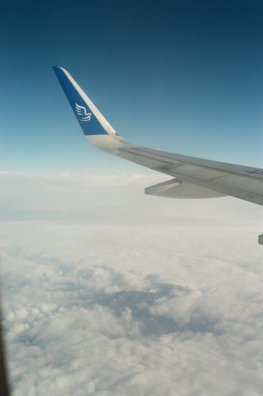 a airplane wing that is over the clouds