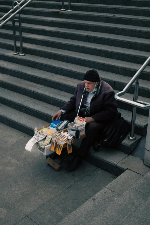 a man sitting on steps and holding bags