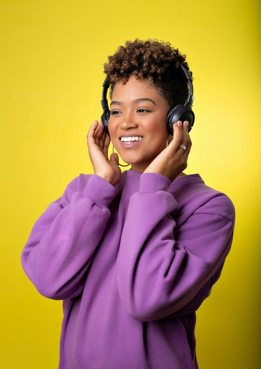 a black woman wearing a purple sweatshirt talking on a cell phone